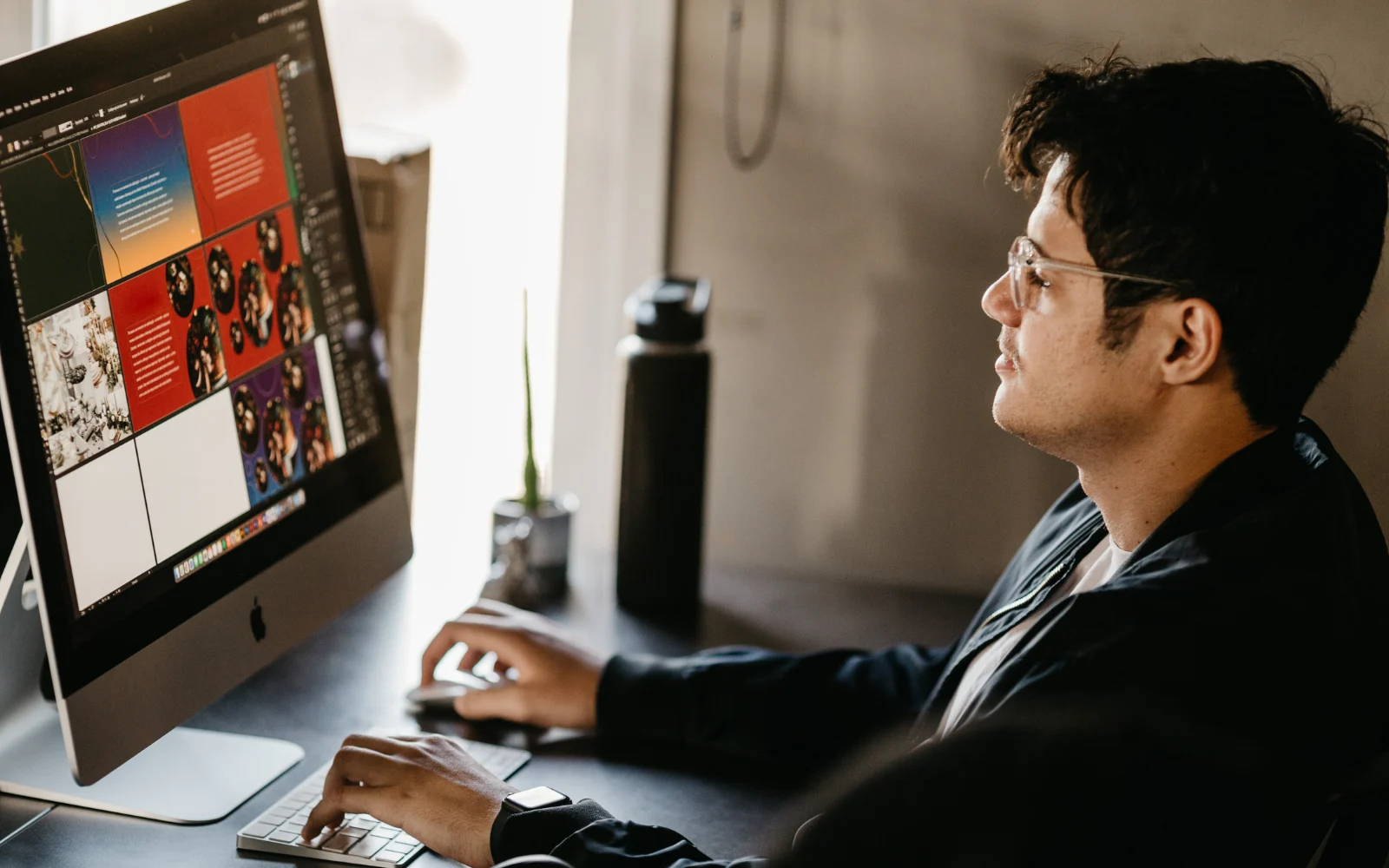 Designer creating consistent brand identity materials on laptop and tablet